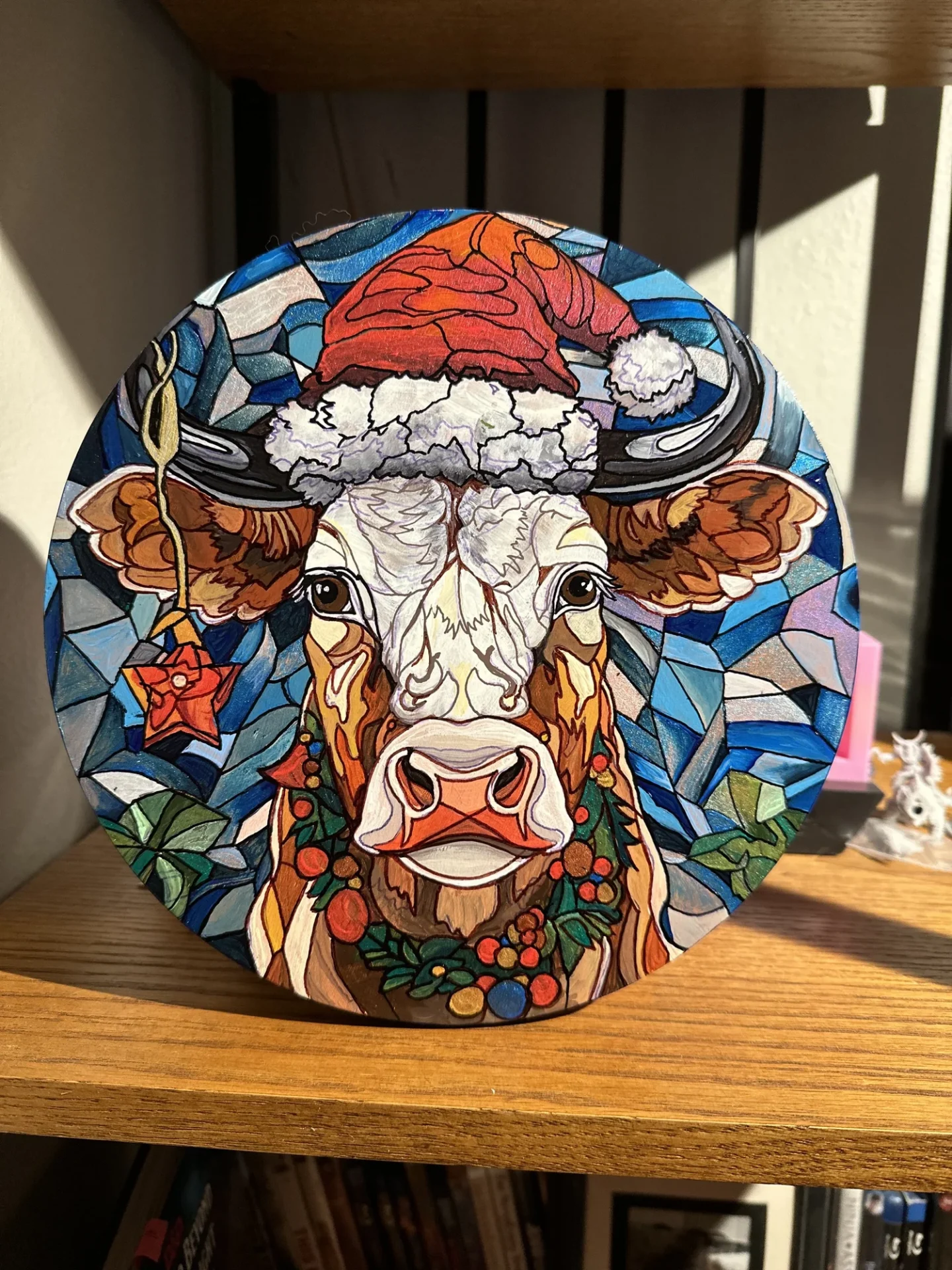 Christmas-themed cow artwork on shelf