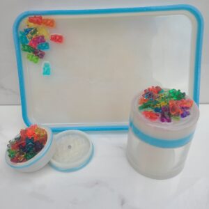 Colorful gummy bears on tray and jars