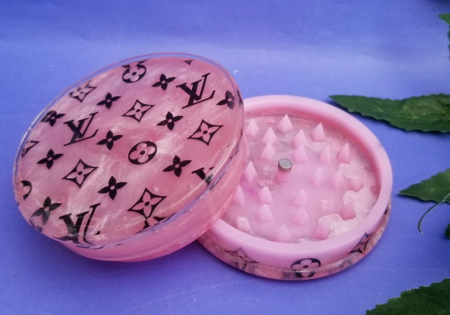 Open pink grinder on purple background